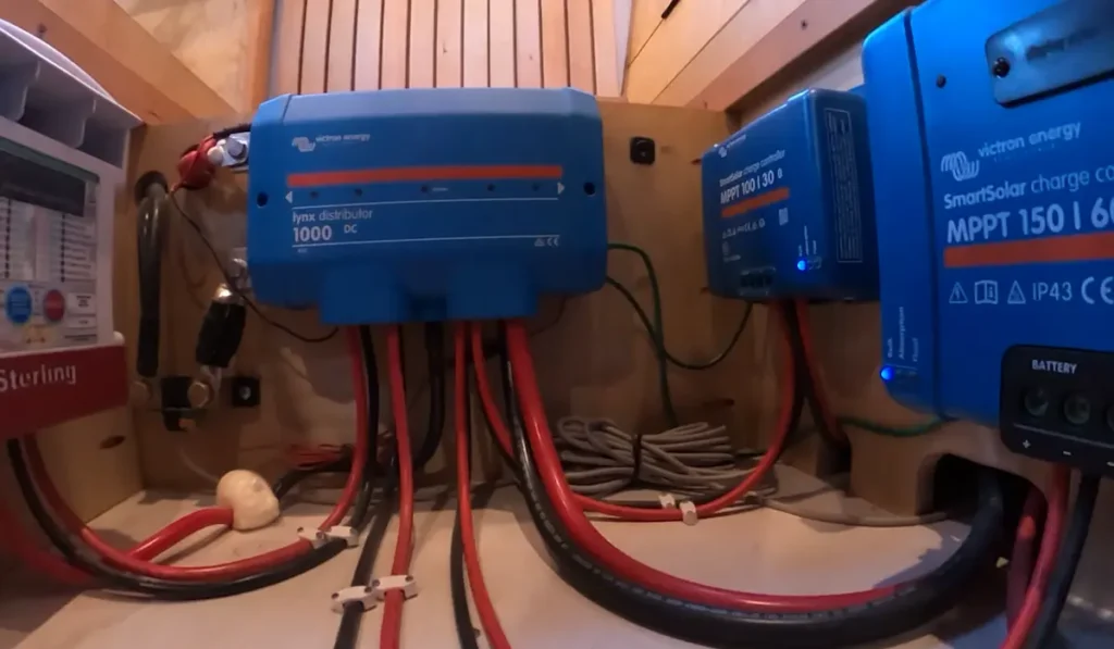 Installed solar energy system inside a skoolie with inverter, MPPT controller, batteries, and wiring