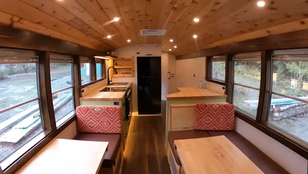 Finished skoolie bus interior with solar-powered lighting turned on after installation