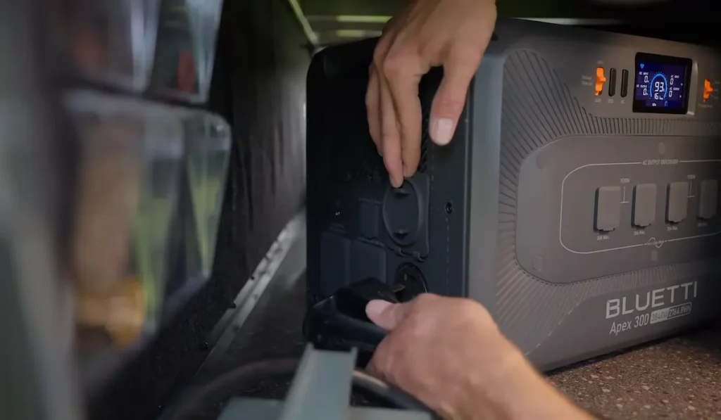 Man setting up a Bluetti Apex 300 power station inside a boondocking RV